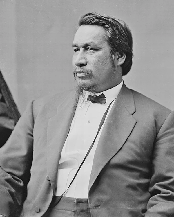 An old black and white photo of a man sitting in profile. He looks focused.