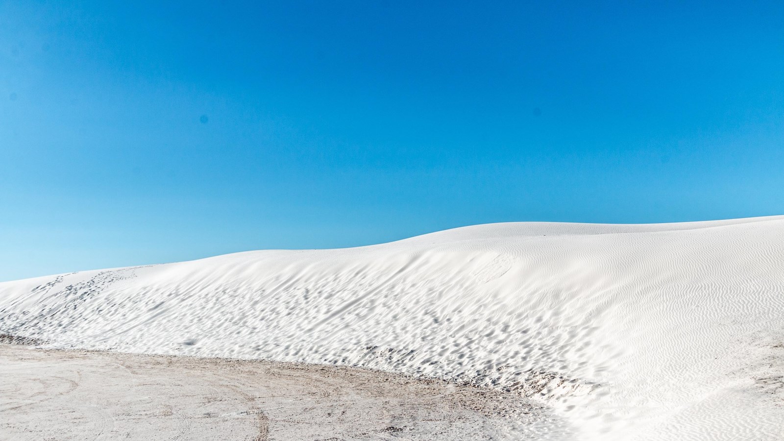 White sand dunes with a blue sky background