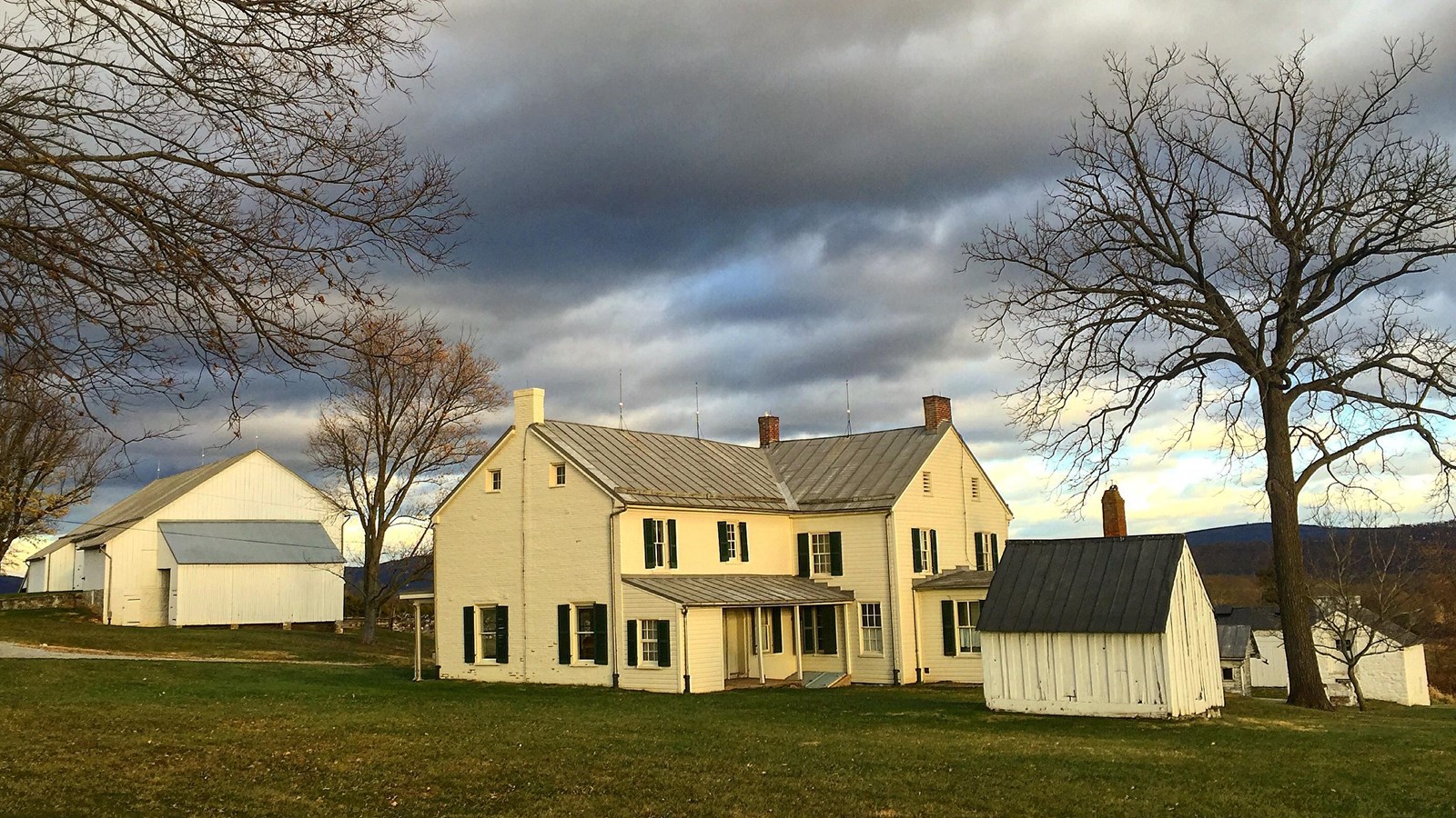 white farmhouse and other small structures