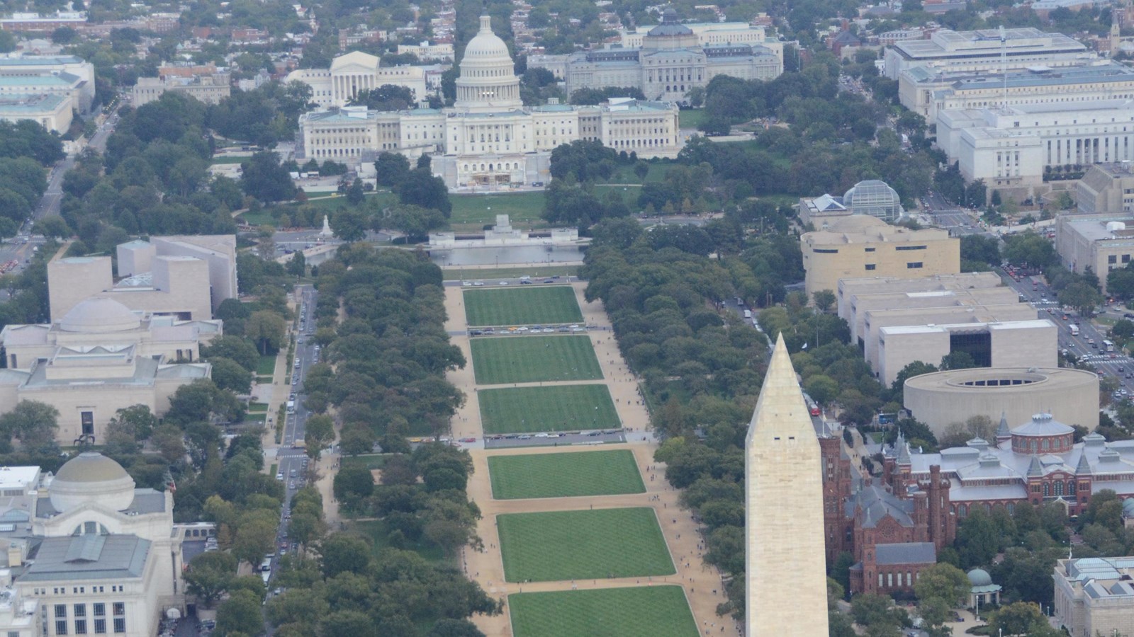Aerial image of green grass between the washington monument and US Capitol