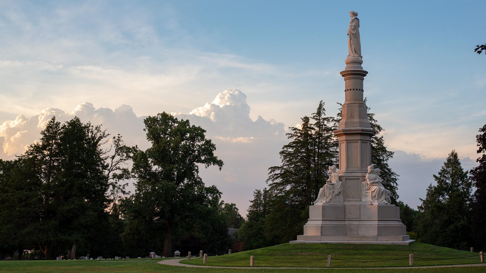 A white marble monument  with a paved walkway leading to the monument