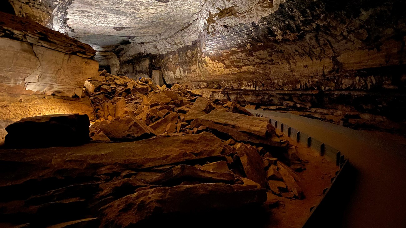 A large cave passage with a paved trail on the right side. 