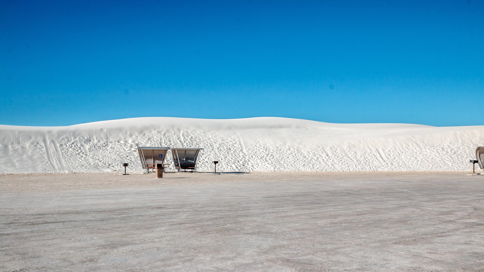 White sand dune with blue sky background.