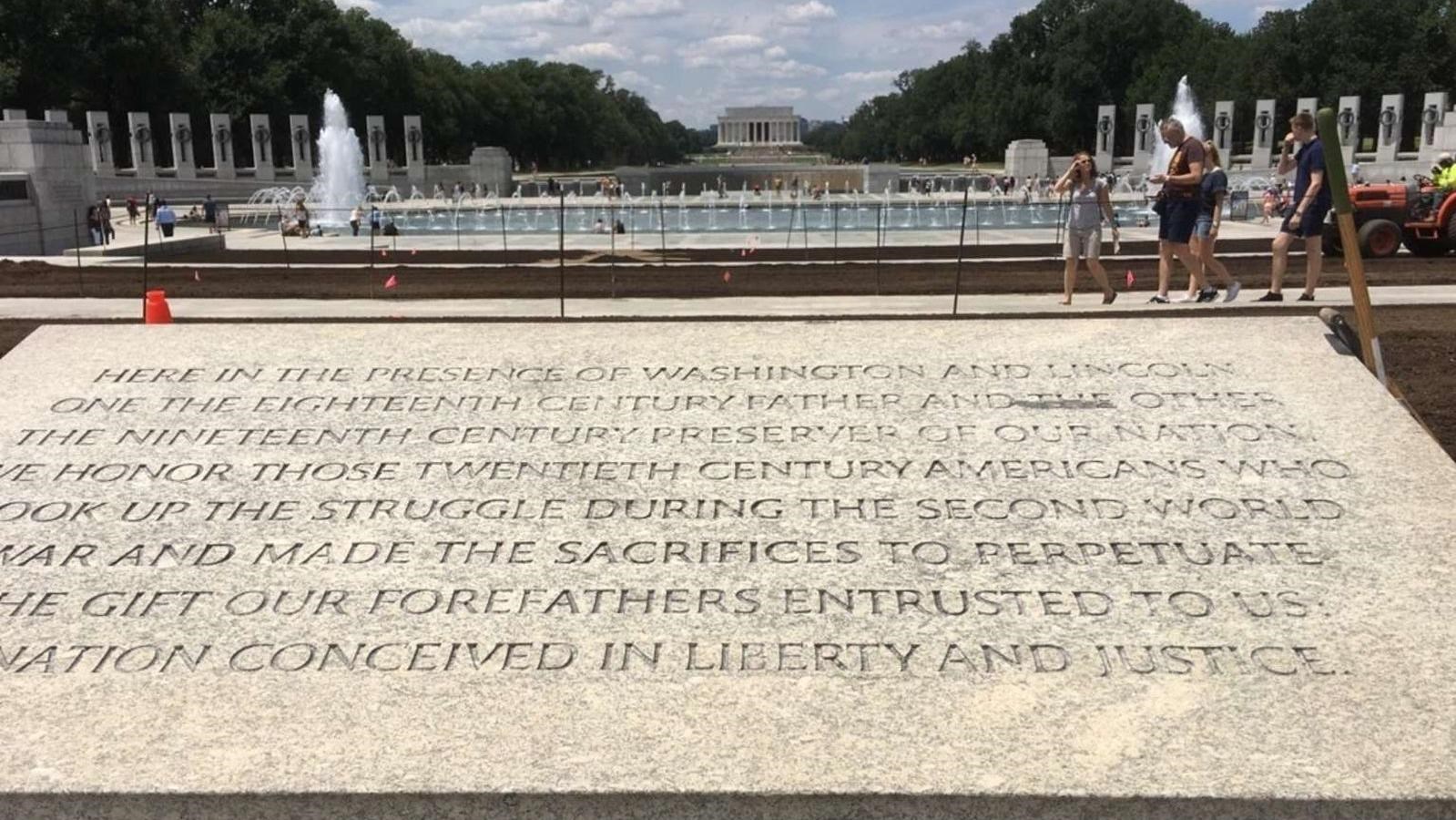 Inscribed plaque with the War World II Memorial with the Lincoln Memorial in the distance.
