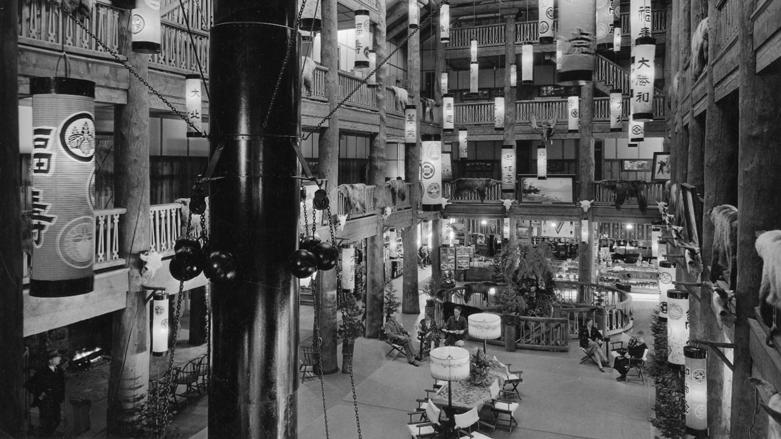 Historic photo of large, open and airy, four-story hotel lobby lined with large Douglas fir columns.