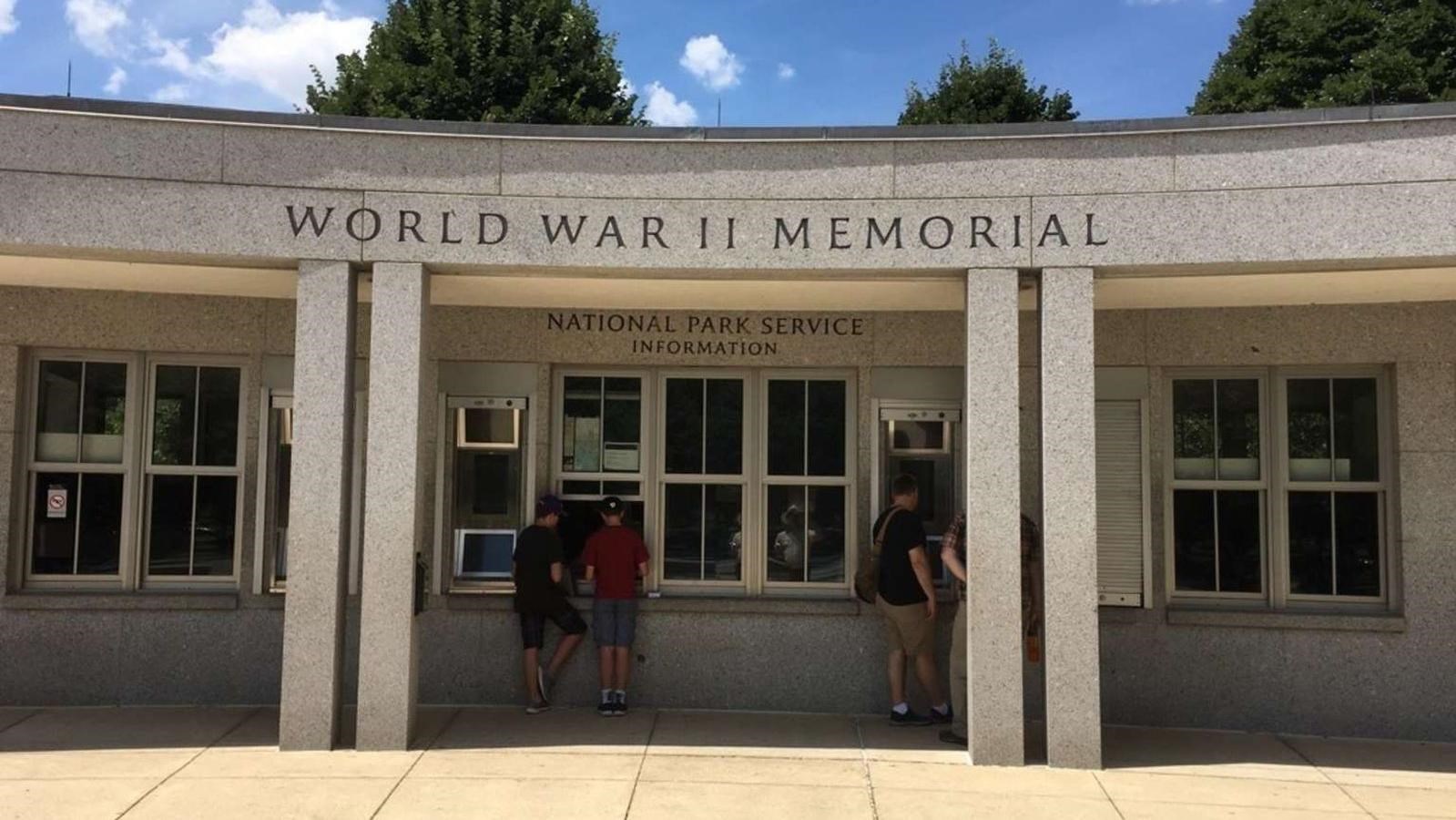 A semicircular information kiosk where visitors are getting information about the memorial.