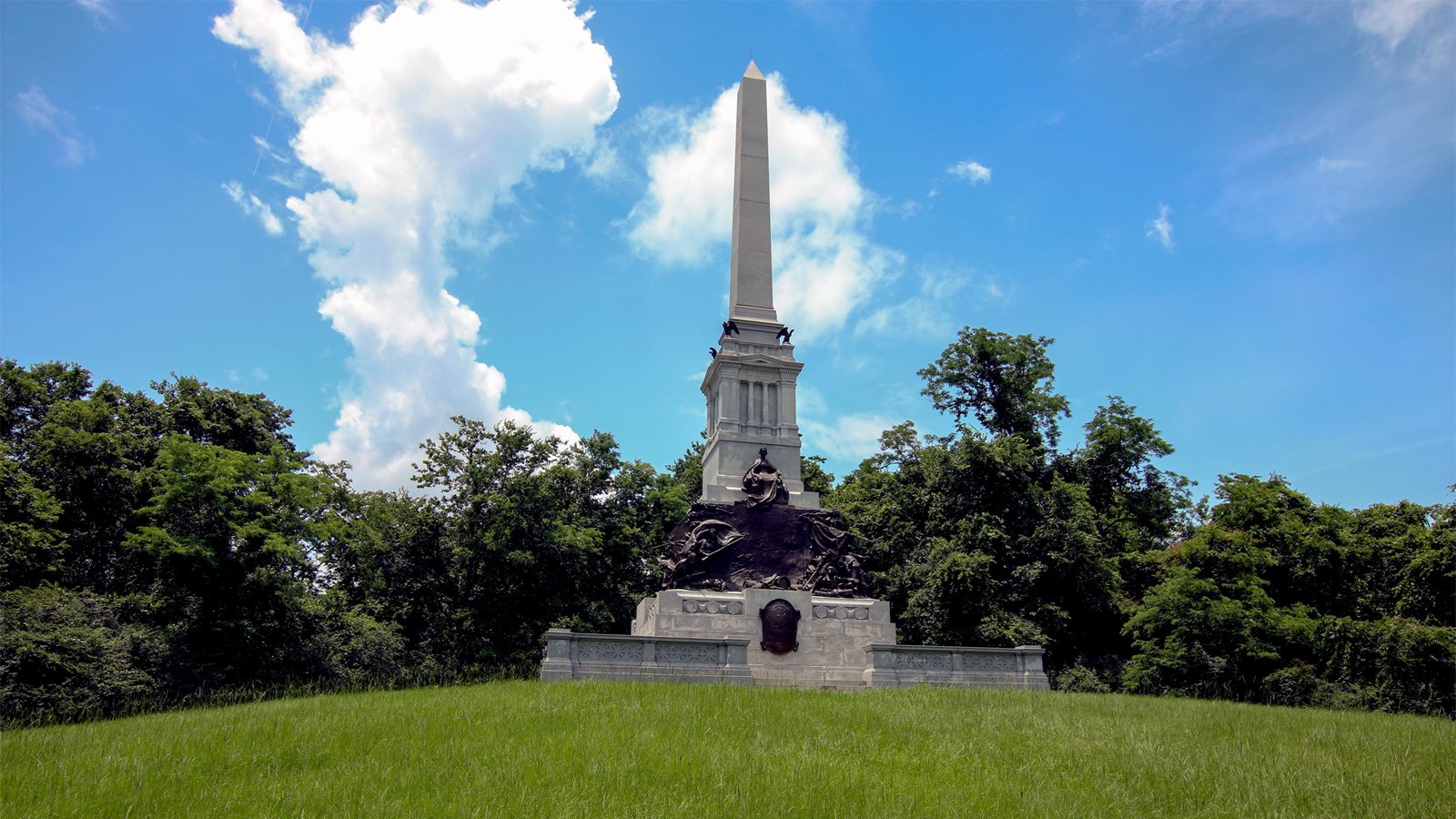 A frontal view of the tall granite monument with white obelisk.