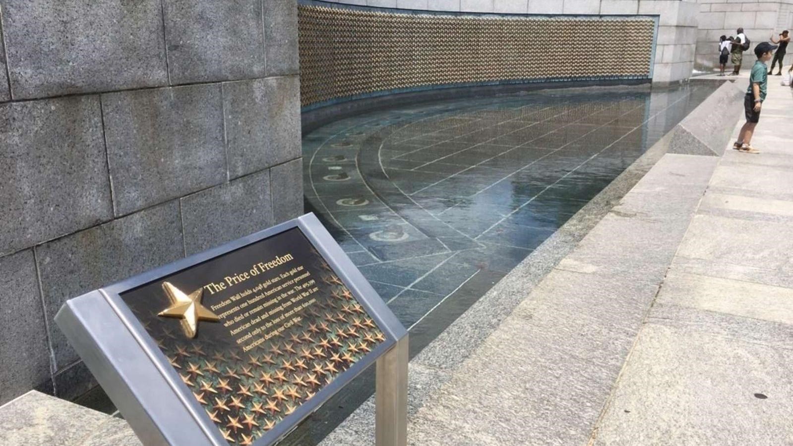 A curved wall covered in golden stars and a plaque in the foreground.