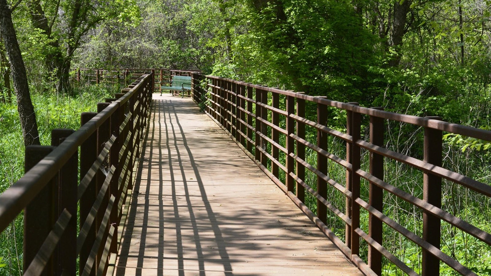 Wooden boardwalk extends adjacent to an original section of the San Antonio River.