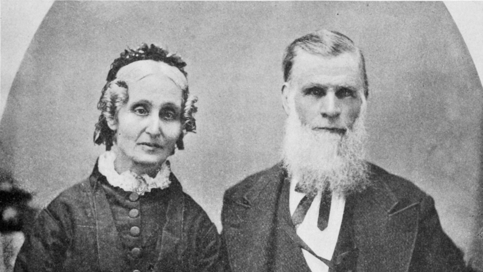 A black and white portrait photo of a woman and a man seated side by side