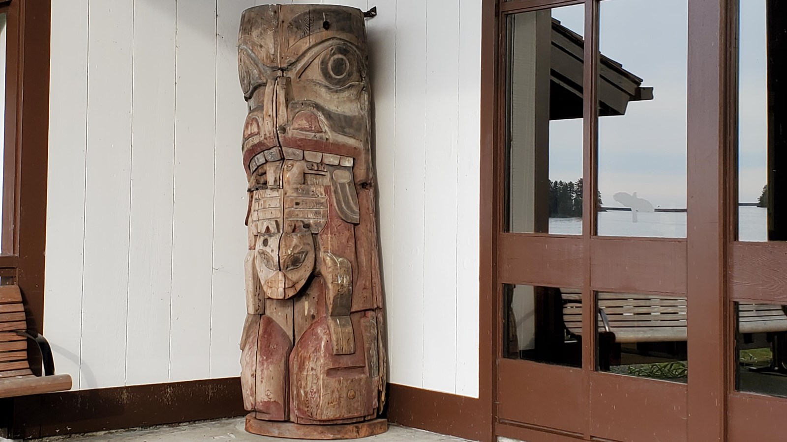 A fragement of an original totem pole on the seaside porch, left of the entrance doors.