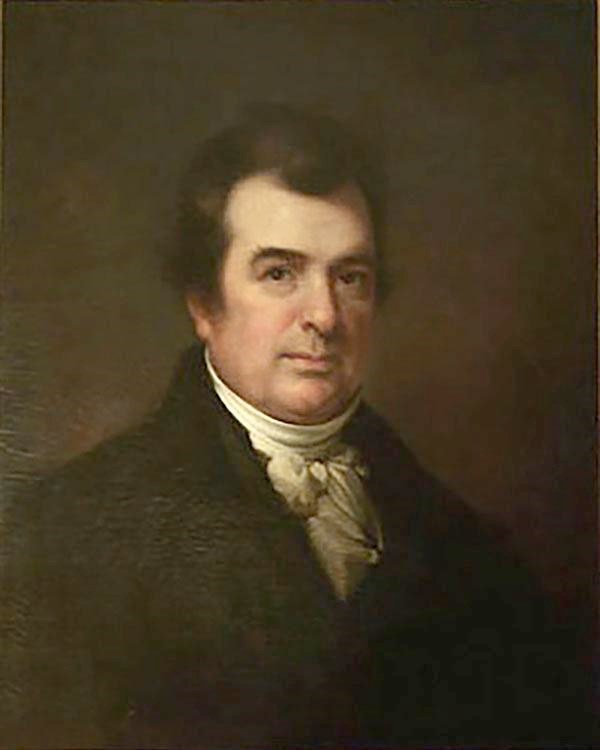 A head and shoulders portrait of a man wearing a brown coat.