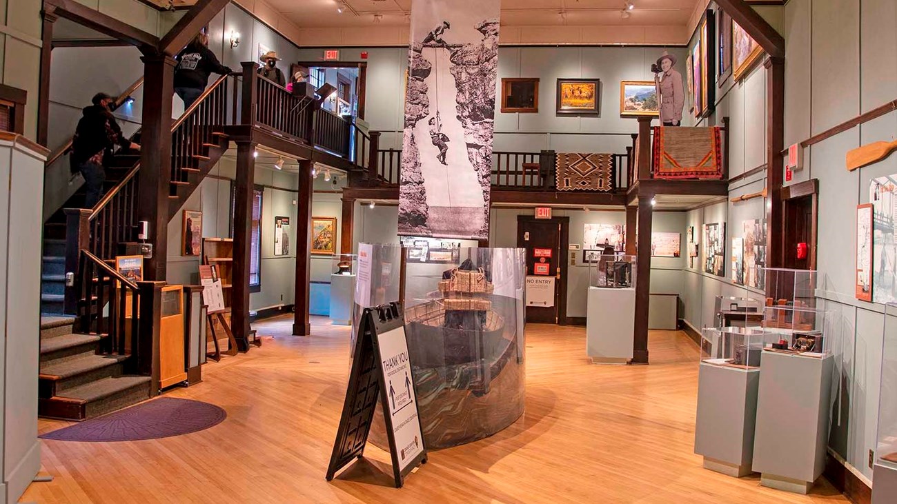 interior of an exhibit hall with a stairway descending from the second story.