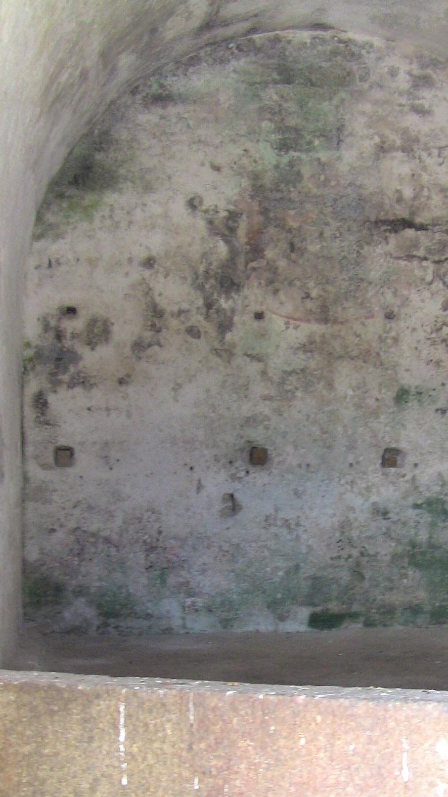 Empty arched ceiling stone room with a dirt floor
