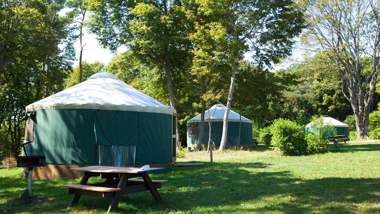 Green tent structures on wooden bases.