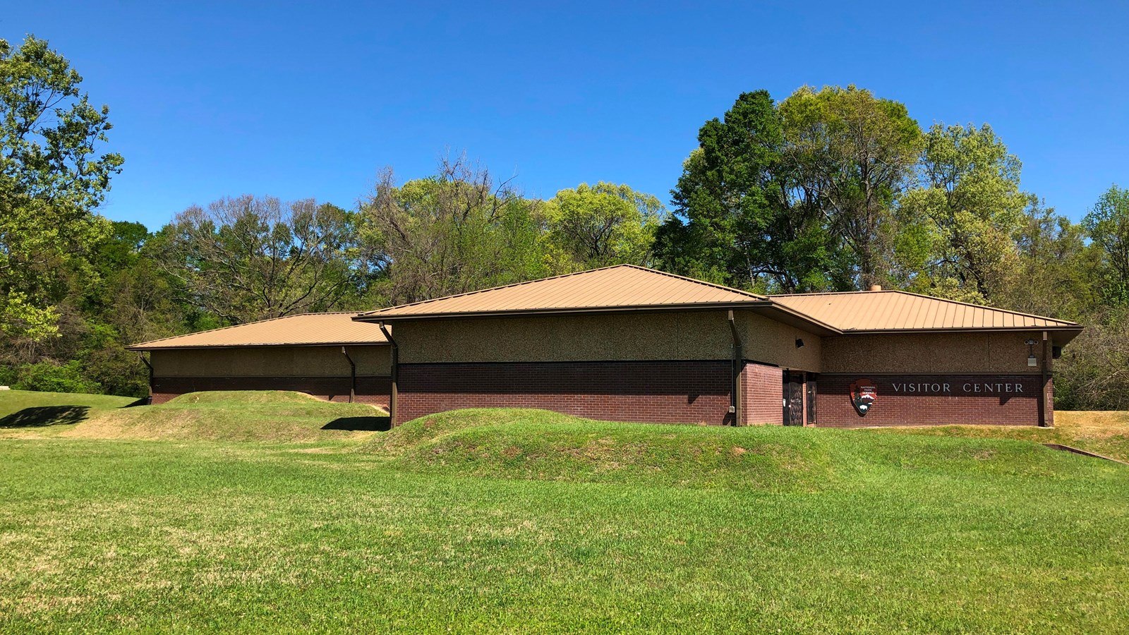 A full view of the park visitor center with landscaped earthen walls.