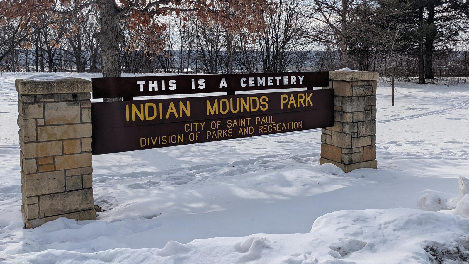 A park sign reading this is a cemetery, Indian Mounds Park. 