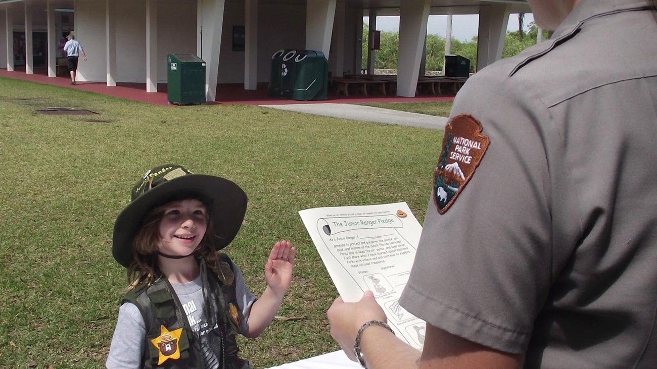 A young Junior ranger wearing a vest with numerous junior ranger badges