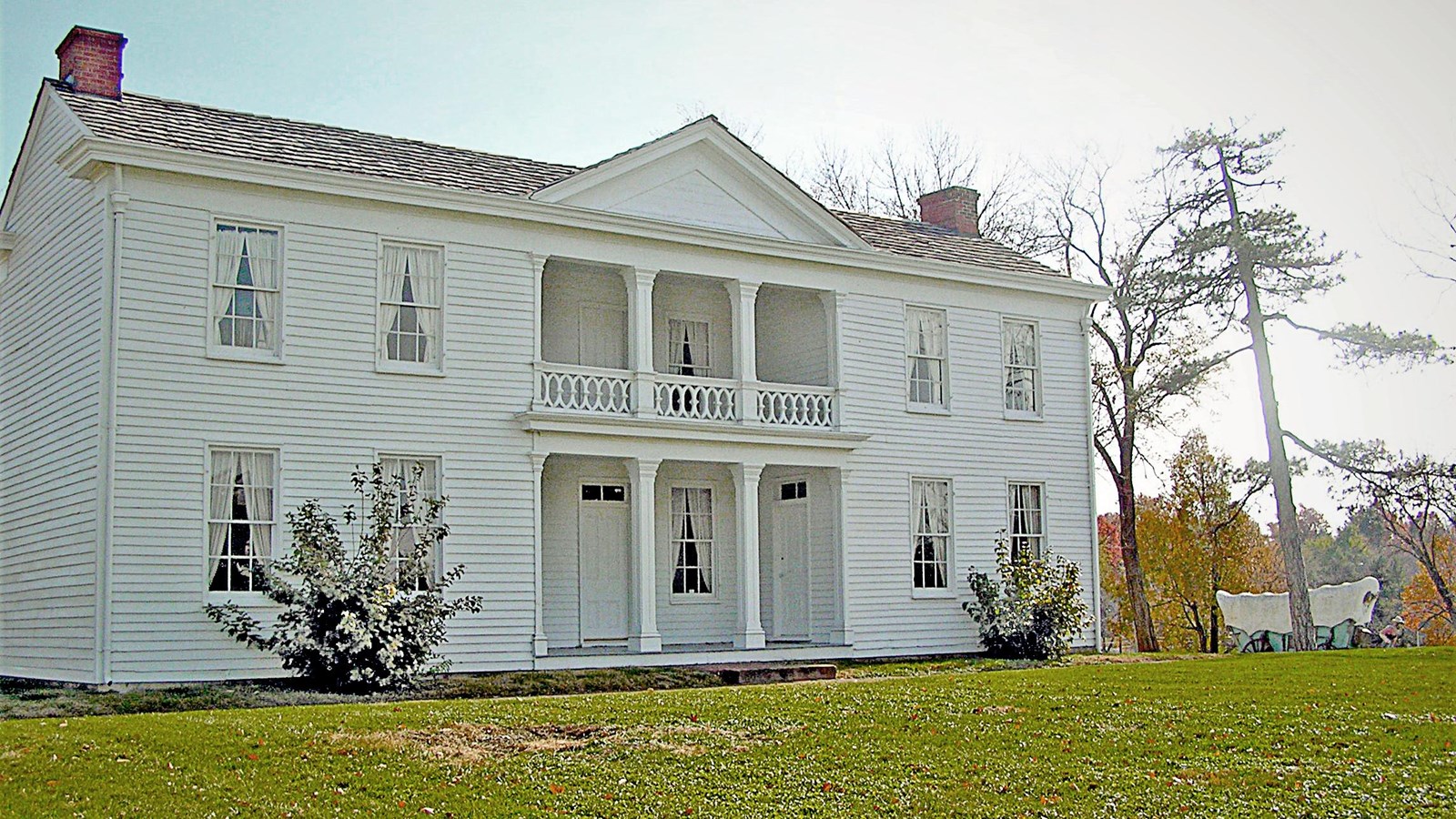 A large white, two story historic home with a grand columns.