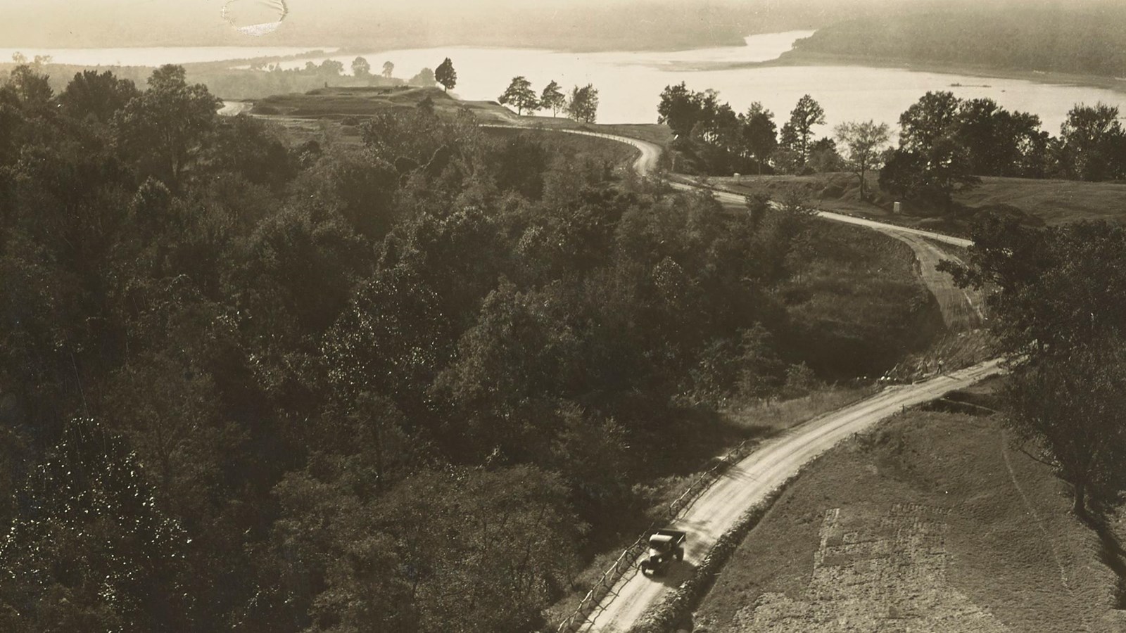 A black and white photo of a road leading to Fort Hill with the canal in the distance.
