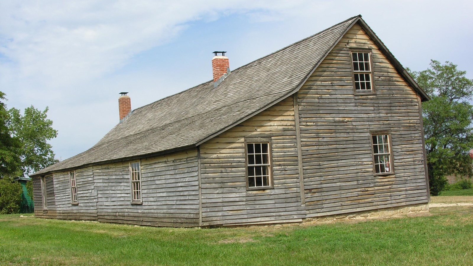 A large wooden barn with a sloping roof.