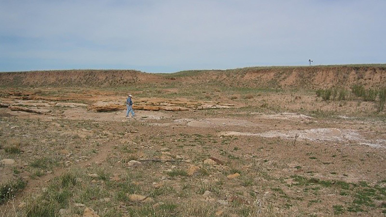 A desert landscape featuring a creek bed with a smooth rock shelf