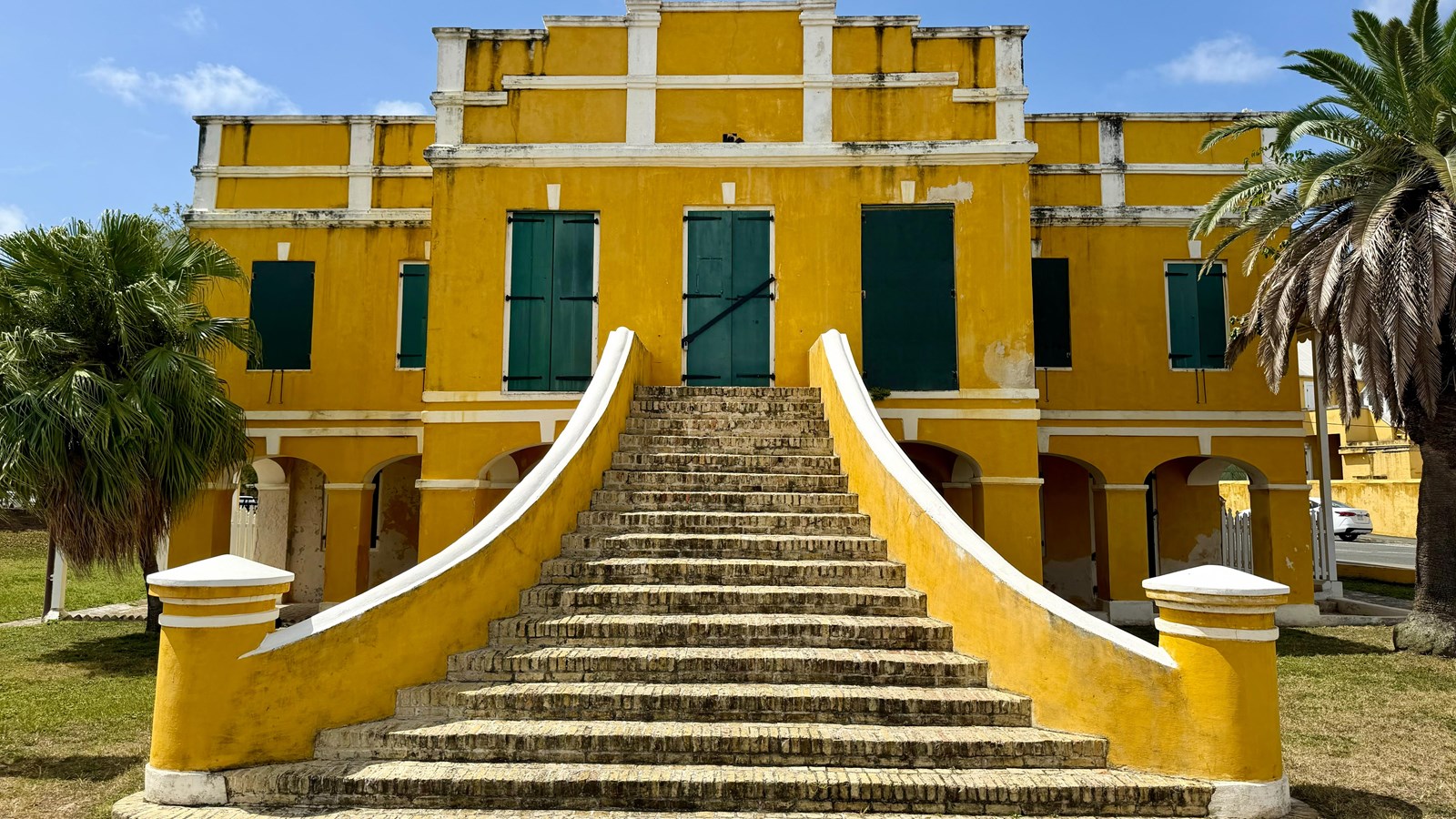 A yellow building with a sweeping staircase