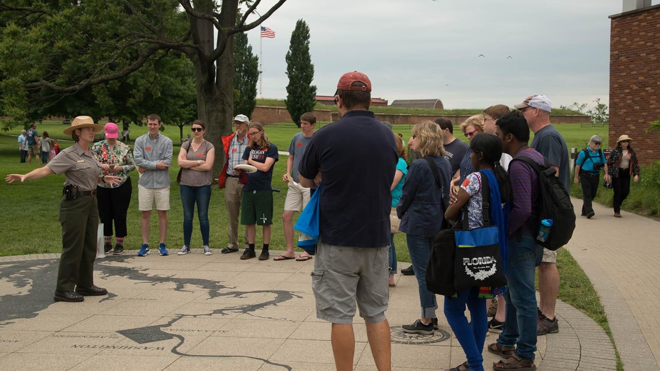a ranger giving a talk to a group of visitors on a cloudy day.
