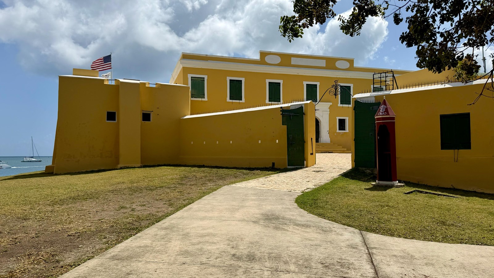 A photo of the entrance to the fort with a red guard booth and flag overhead