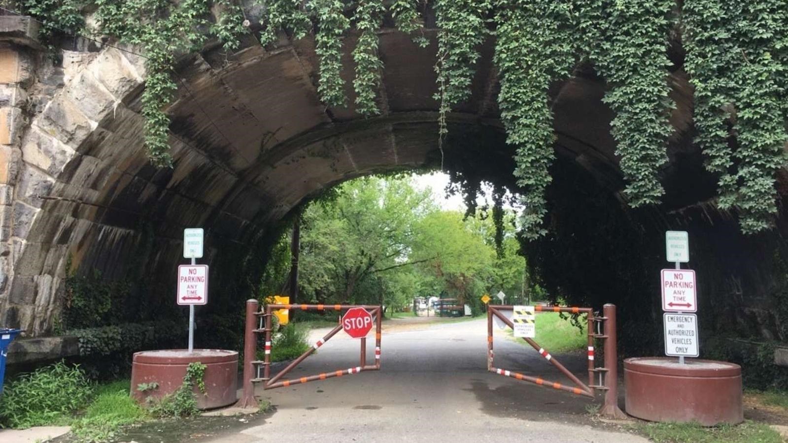 The Capital Crescent Trail begins under an arched stone bridge.