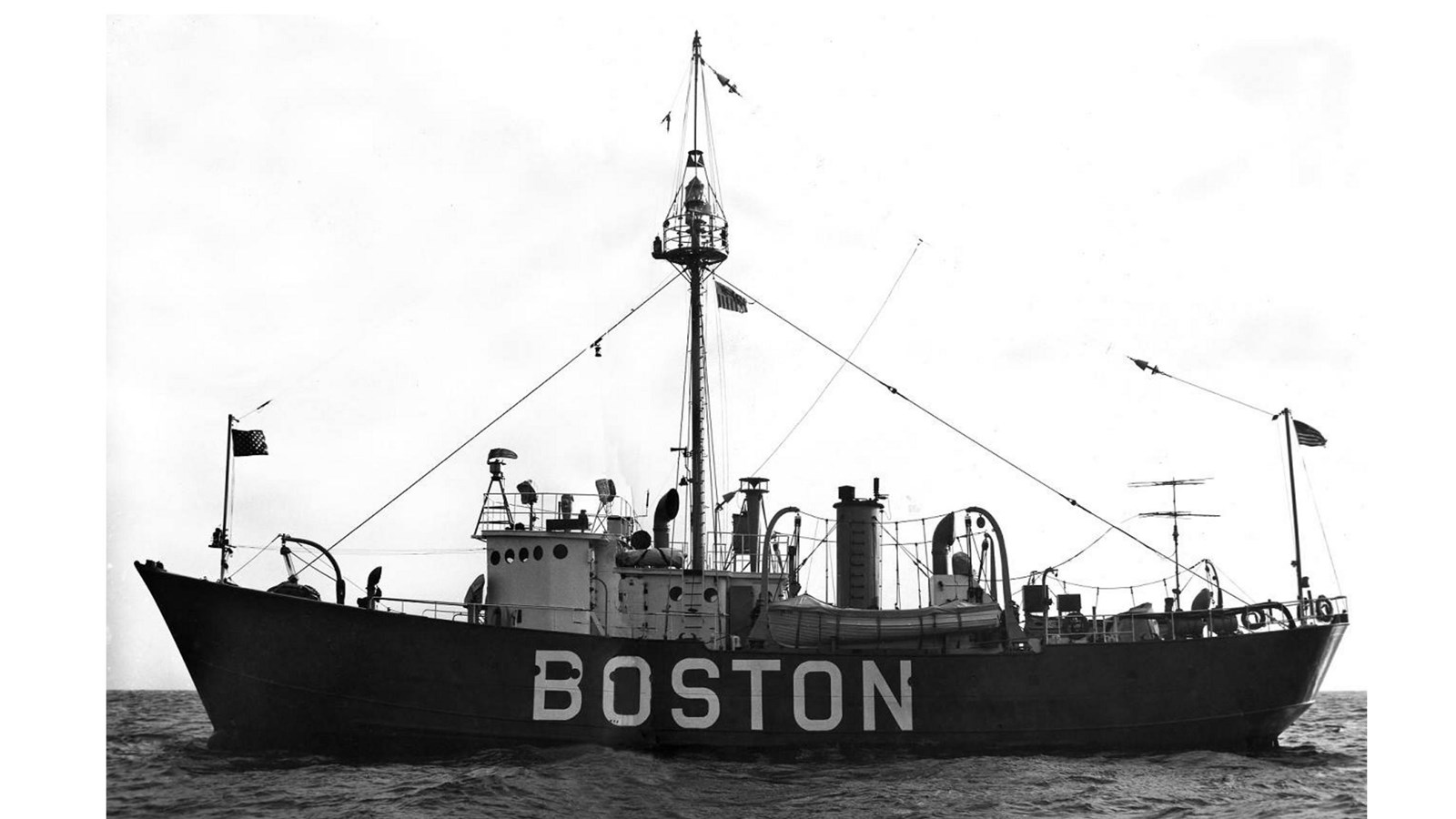 A large vessel with one tall mast, has the word 