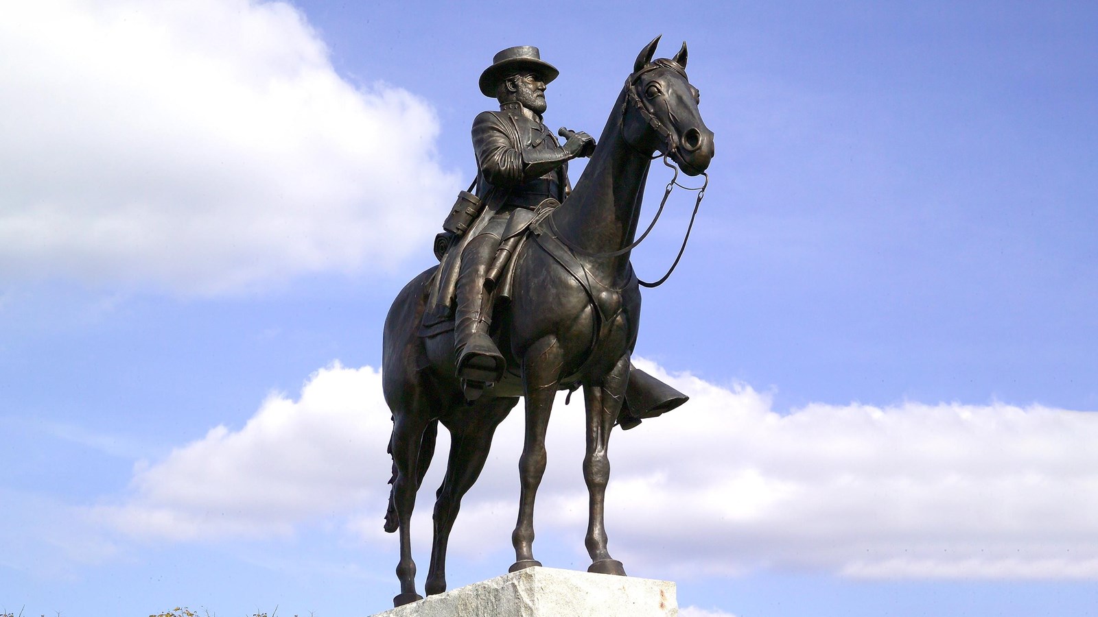 A bronze statue of a man sitting on a horse.