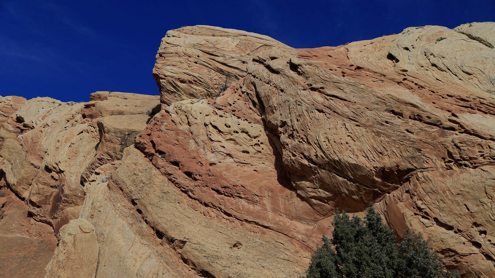 A large close up of beige colored sandstone pointing skywards.