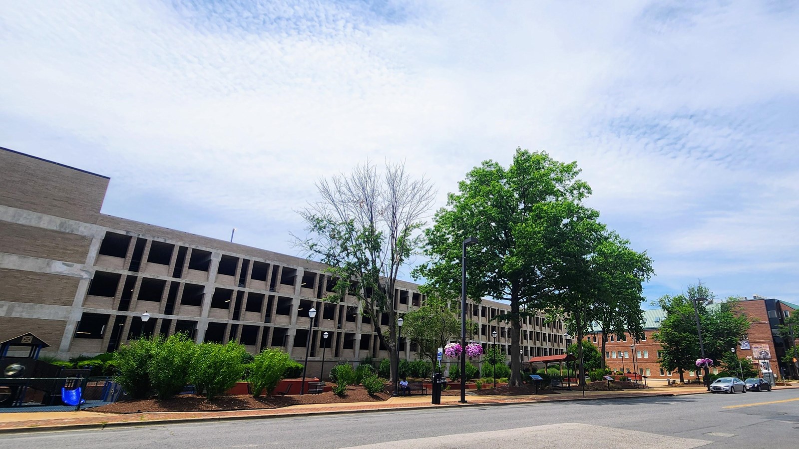 A building with a park in front of it and some trees.