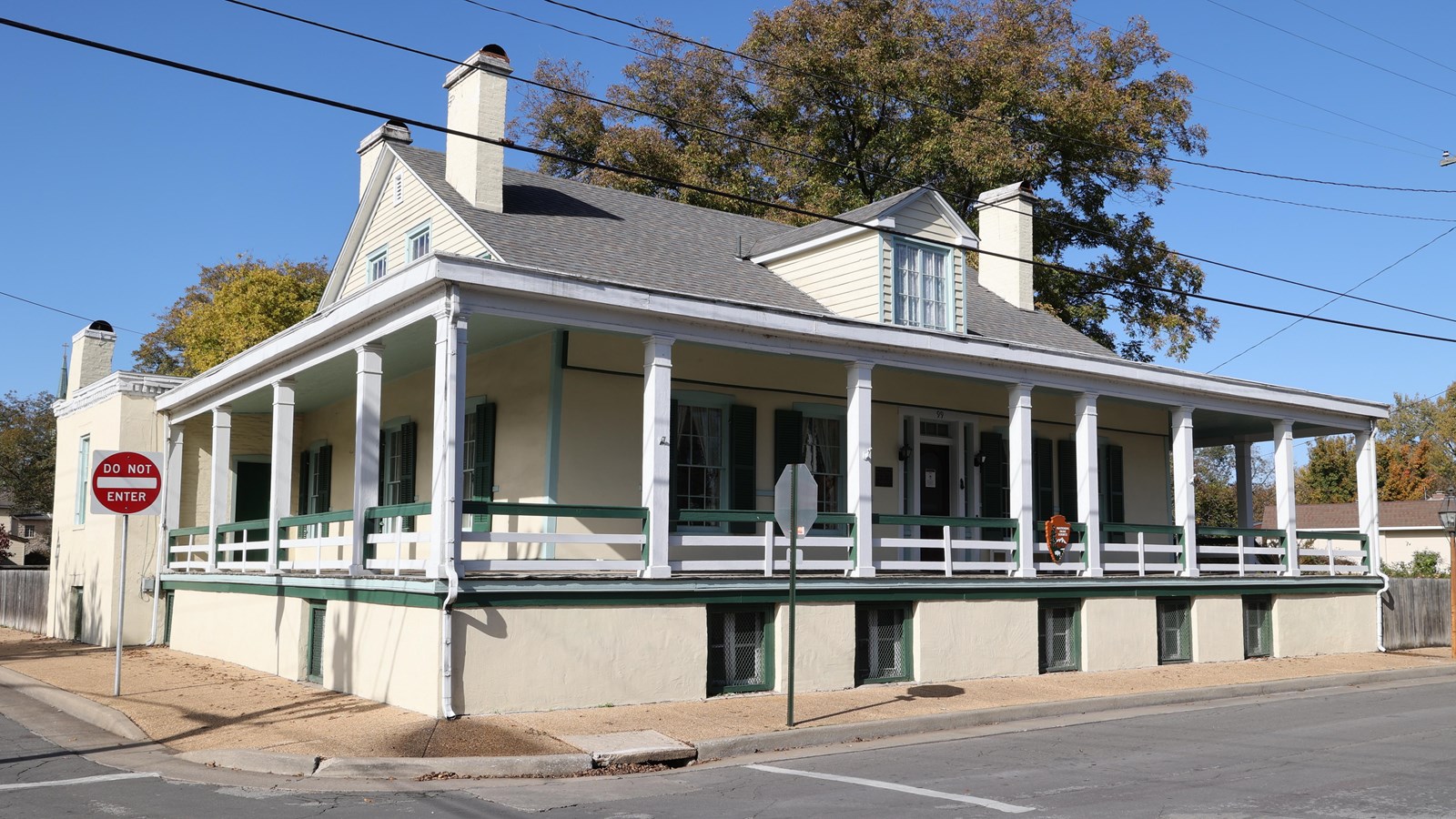 Yellowish two-story home, with white and green accents.