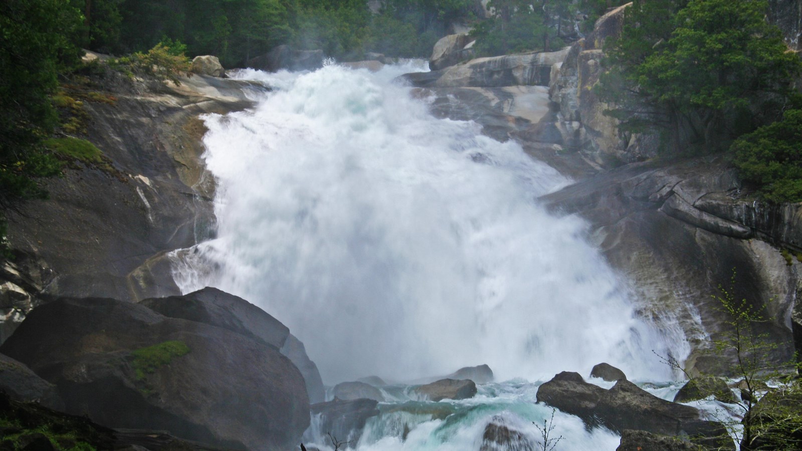 a large waterfall over a steep granite slope