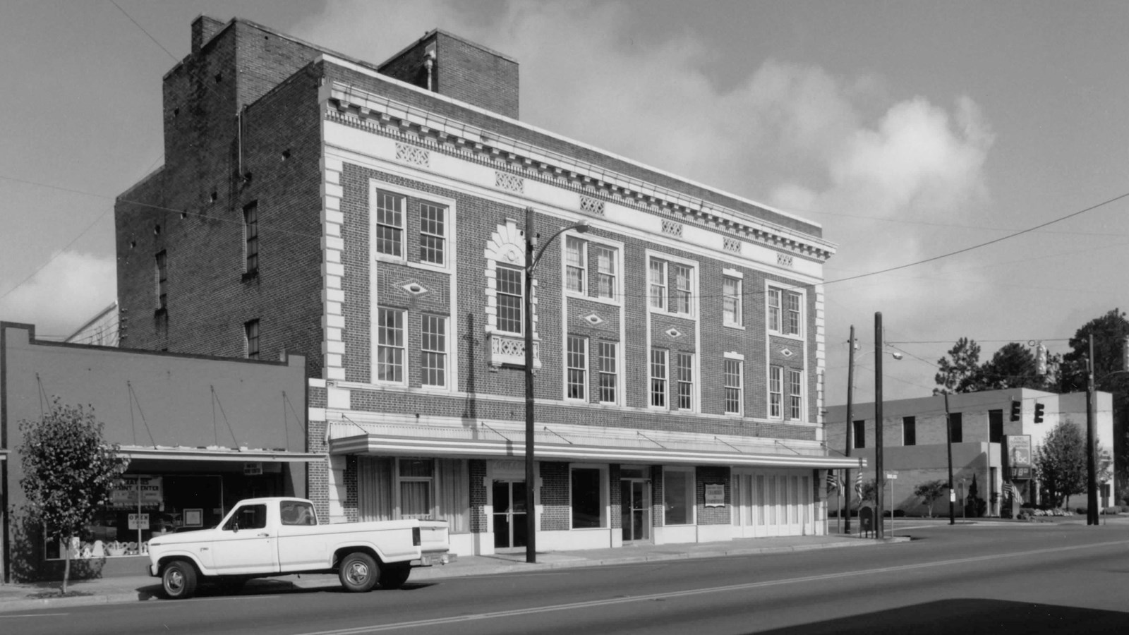 Three-story, red-brick building with a roof deck and basement, in the commercial style