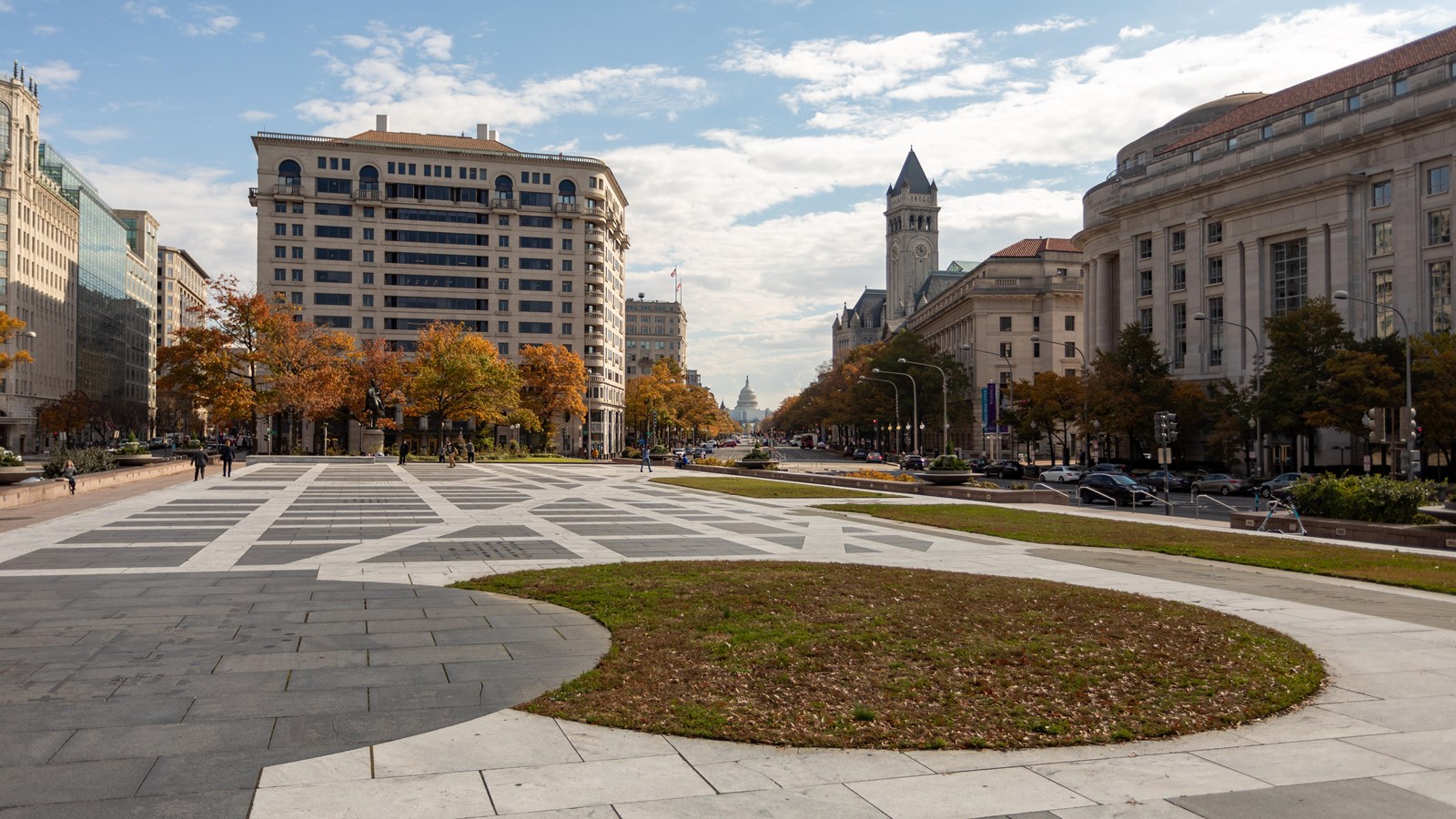 Plaza surrounded by swatches of grass and buildings.