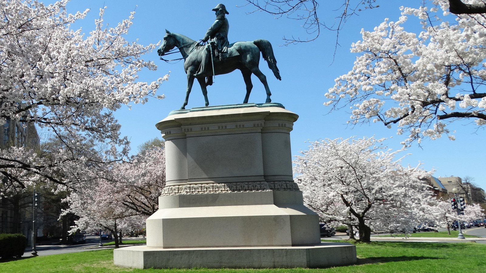 Bronze equestrian statue of a man in military uniform on a large stone pedestal