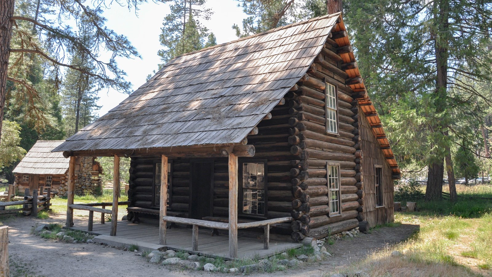 Two story wooden cabin with covered porch