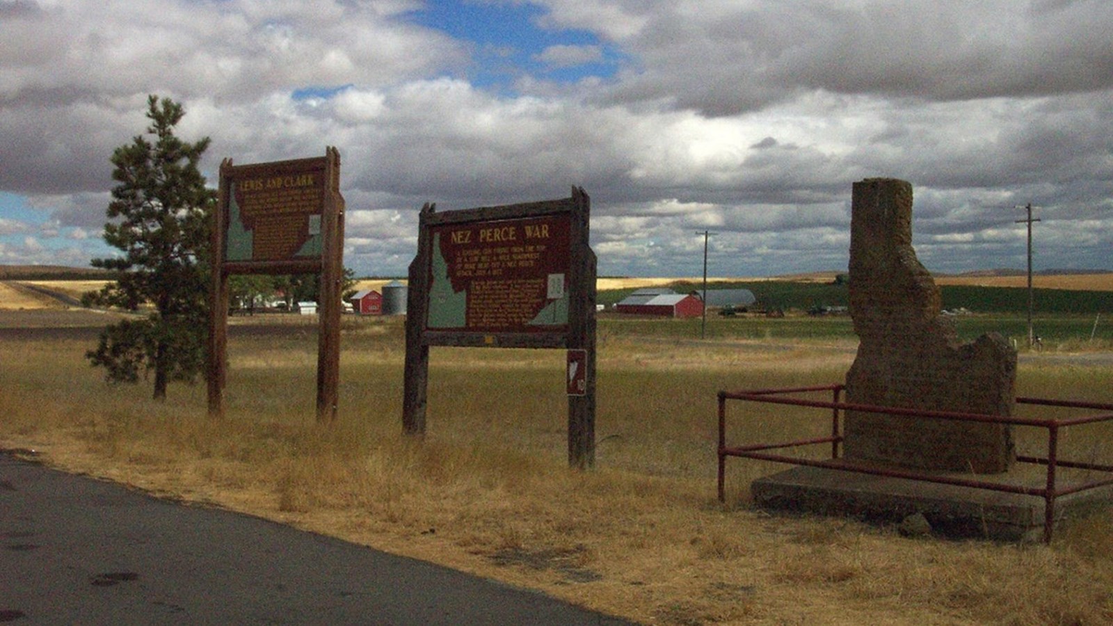 Roadside pullout with two information boards and a stone marker