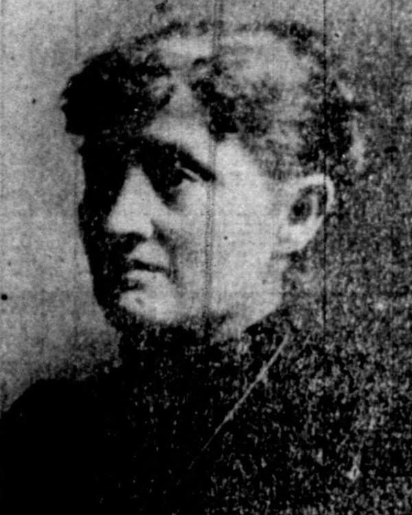Black and white profile of a woman. She is wearing dark clothes and her hair is pulled back.