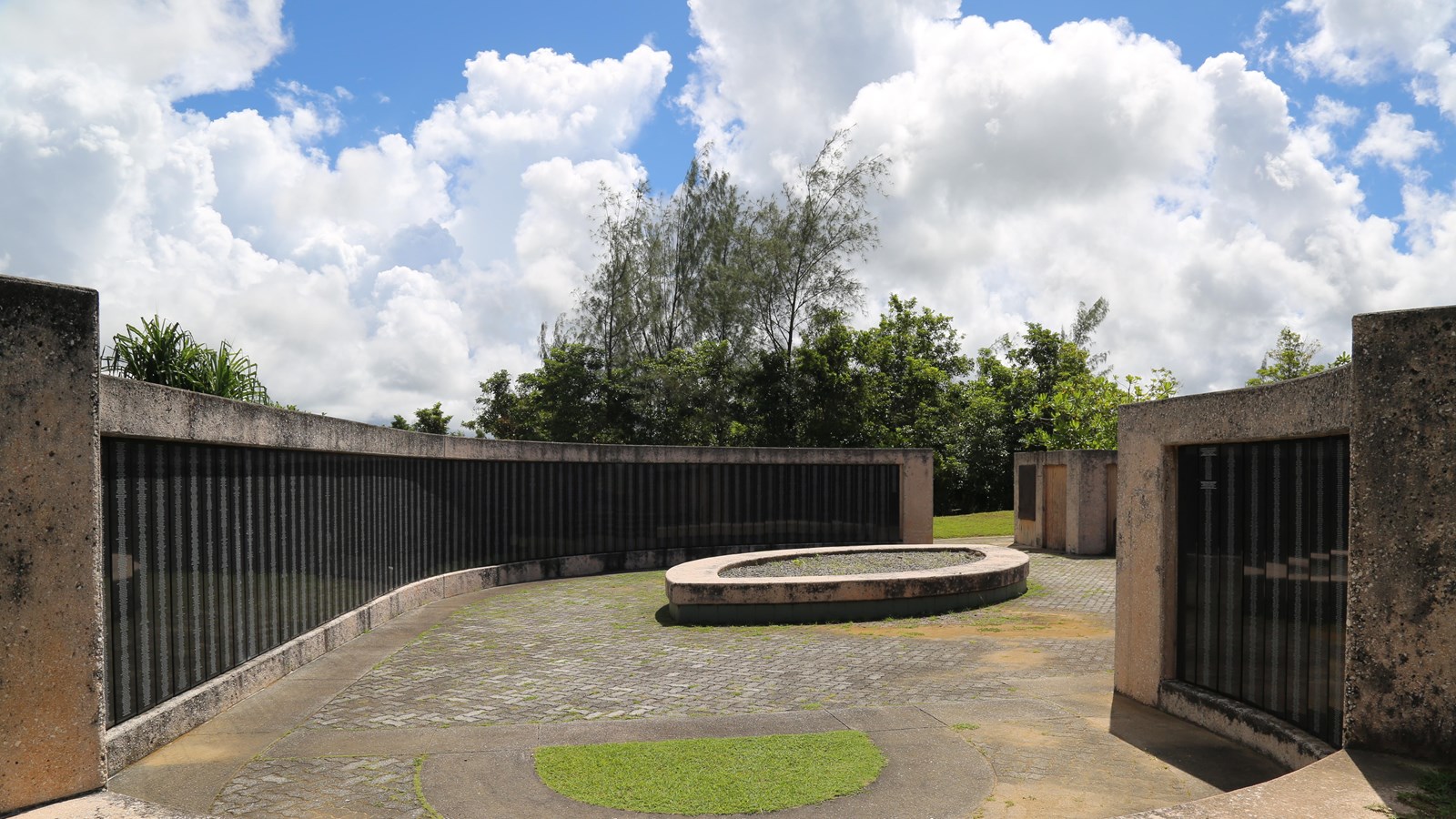 A series of curved walls. On the walls are plaques with names inscribed on them.