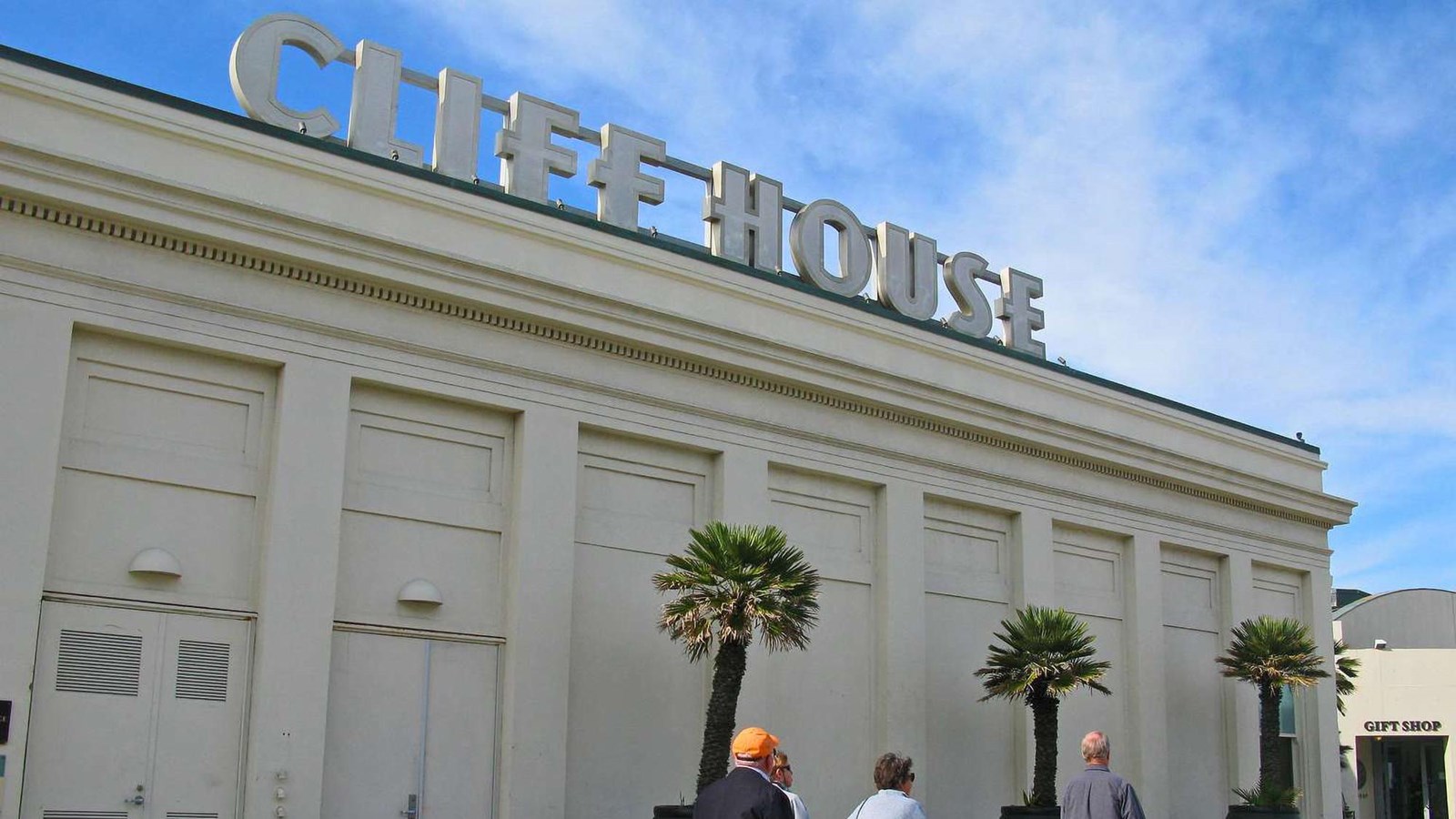 Visitors walking by the entrance to the Cliff House. 