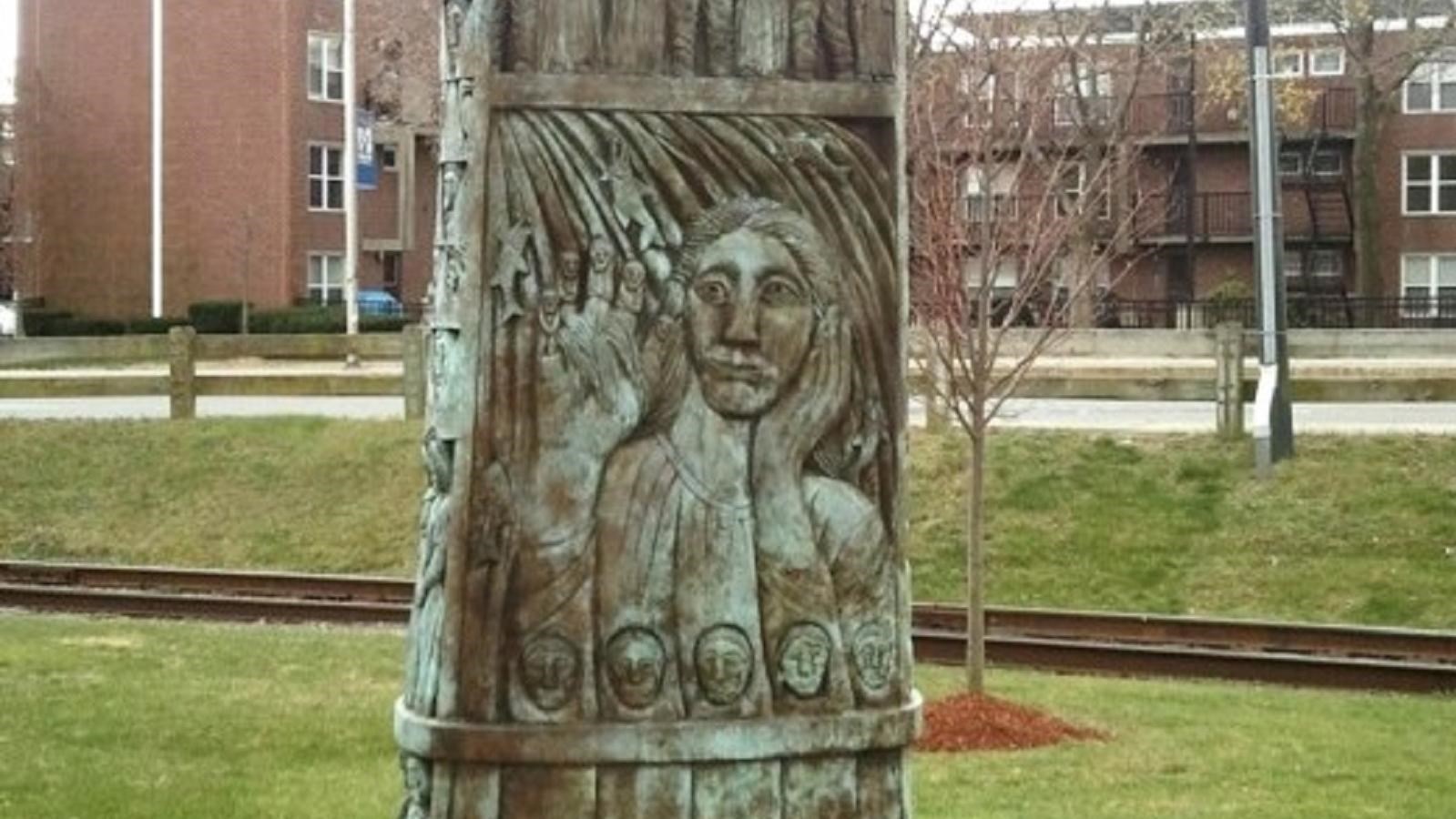 A bronze sculpture featuring designs of animals and people by a river