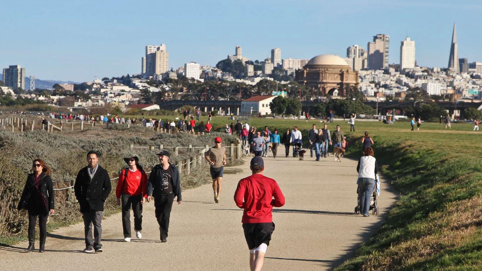 People on the Golden Gate Promenade with San Francisco behind.