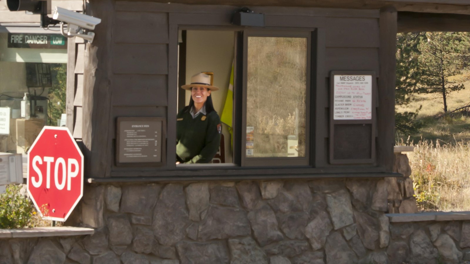 a ranger smiles from the fee booth window