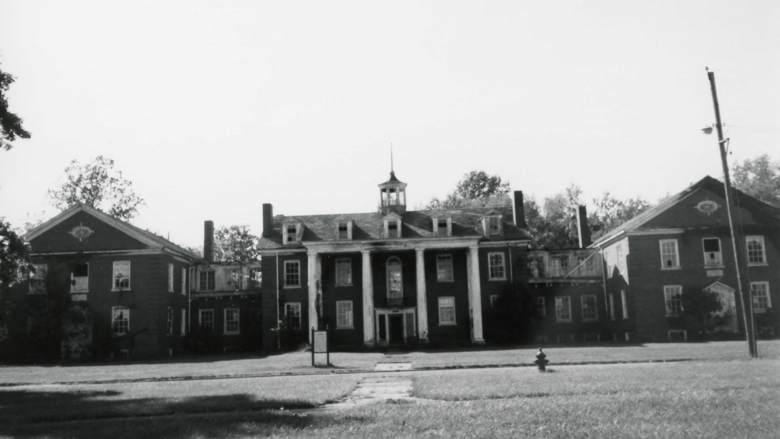 Two-and-a-half story campus dormitory with 4 pillars in front entryway