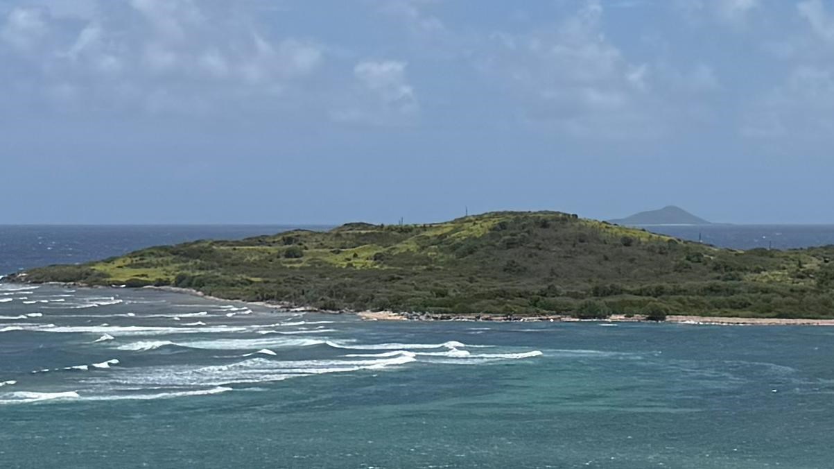 Image of a hazy island in the distance beyond the ocean.