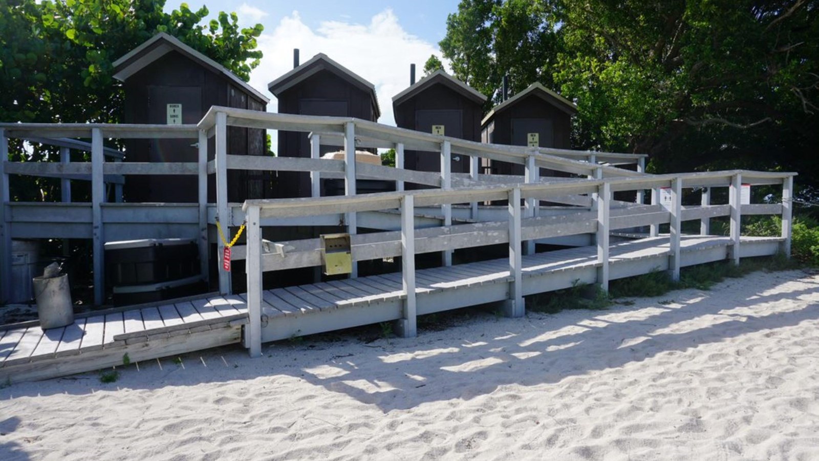 four toilet huts sit tucked in the trees